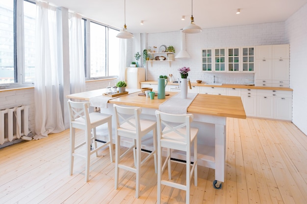 Stilvolle Küche in hellen Farben in einer trendigen modernen Maisonette-Wohnung mit großen hohen Fenstern.