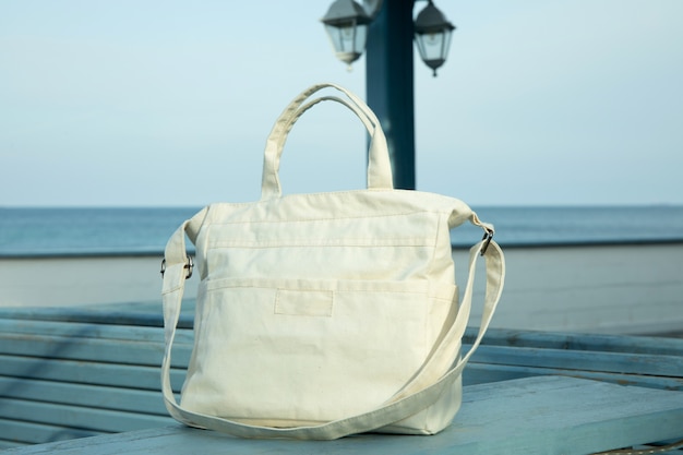 Foto stilvolle öko-tasche im freien auf holztheke gegen seehorizont