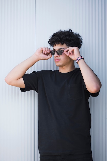 Foto stilvoller ethnischer kerl in der sonnenbrille mit dem gelockten haar