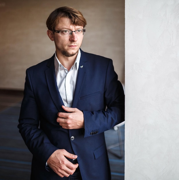 Stilvoller europäischer Mann mit Brille am Fenster