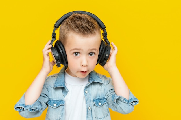 Stilvoller kleiner Junge, der Musik über Kopfhörer hört und genießt