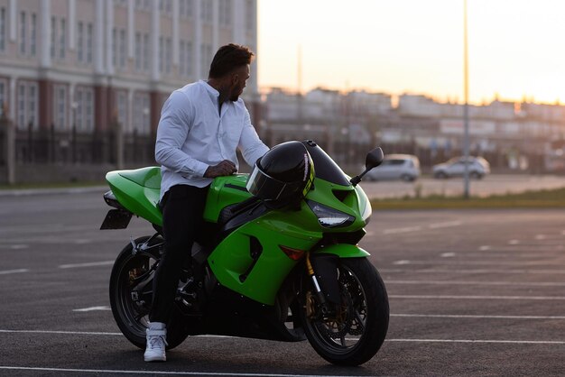 Stilvoller Mann auf dem Motorrad am Abend