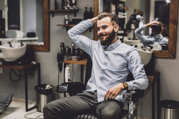 Foto stilvoller mann, der im friseursalon aufwirft