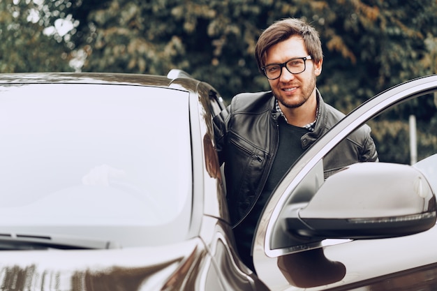 Stilvoller Mann in der Brille sitzt in einem Auto
