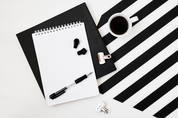 Stilvoller minimalistischer arbeitsplatz mit notebook, bleistift, tasse kaffee und kabellosem kopfhörer