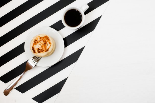 Stilvoller minimalistischer Arbeitsplatz mit Tasse Kaffee und Bäckerei