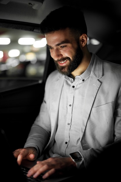 Stilvoller moderner Geschäftsmann arbeitet im Auto.