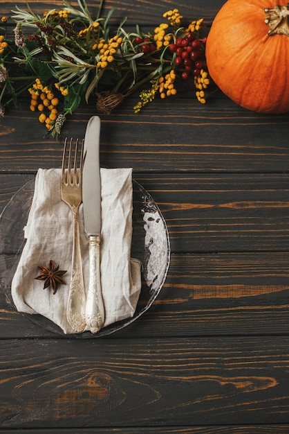 Stilvoller Thanksgiving-Dinner-Tisch, moderner Teller mit Vintage-Besteck, Leinenserviette, Anis