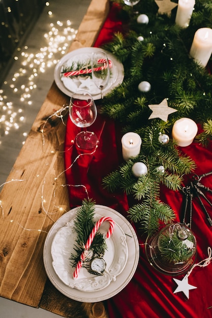 Stilvolles Gedeck mit brennenden Kerzen und Weihnachtsdekorationen