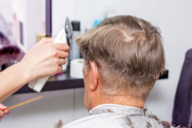 Stilvolles Haarstyling für einen älteren Mann im Friseursalon