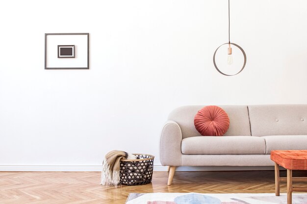 Stilvolles Interieur des Wohnzimmers mit grauem Designsofa, Möbeln, runder Pendelleuchte, eleganten Accessoires und Fotorahmen in minimalistischer Wohnkultur.