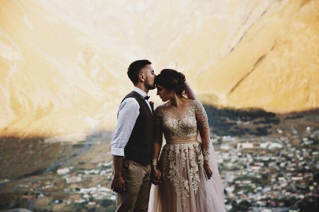 Stilvolles junges Hochzeitspaar hat den Spaß, der in den schönen georgischen Bergen aufwirft