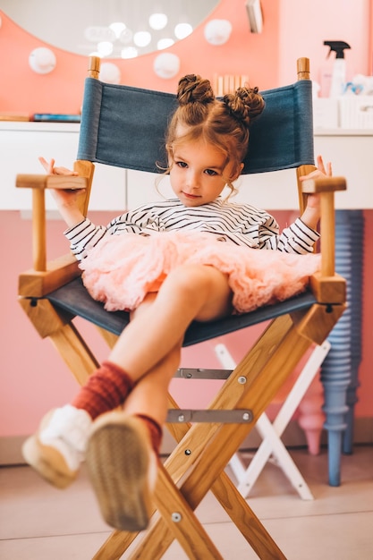 Stilvolles kleines Mädchen in einem Schönheitssalon für Kinder, wo sie eine schöne Frisur machte Schönheits- und Kindermode mit gesundem Haar