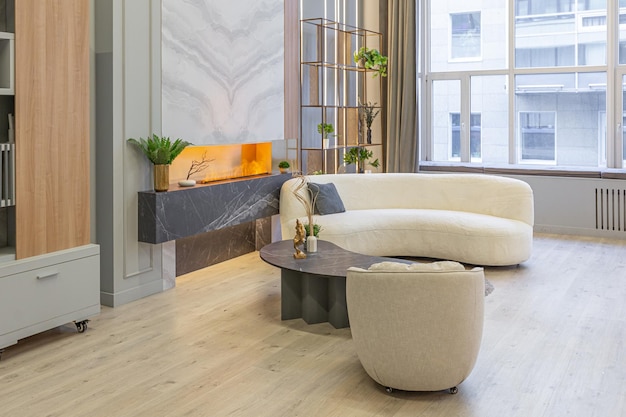 Stilvolles, luxuriöses interieur eines modernen studio-apartments in grünen pastellfarben mit holzelementen, teuren möbeln und dekorationen, gemütliche sitzecke neben dem kamin