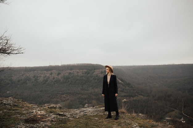 Stilvolles Mädchen macht eine Pause und genießt Bergblick.