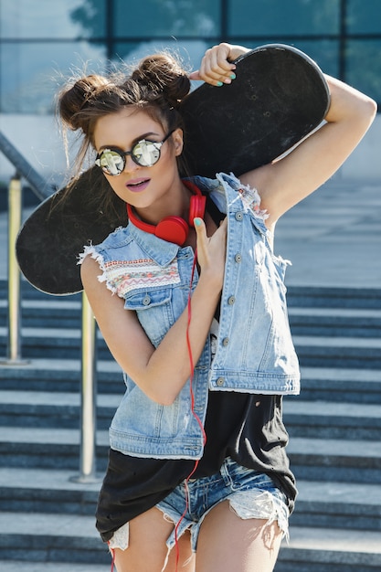 Stilvolles Mädchen mit einem Skateboard