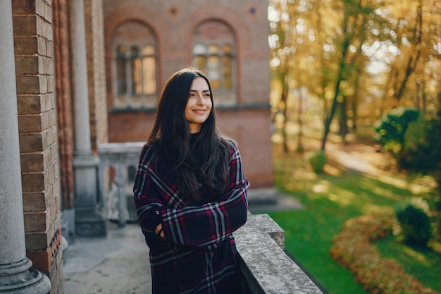 stilvolles Mädchen, welches die Stadt und den Park im Herbst erforscht