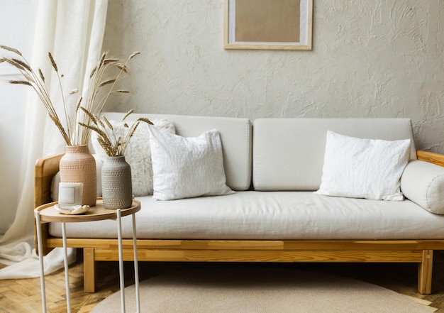 Stilvolles skandinavisches, modernes, weißes, gemütliches Öko-Interieur im minimalistischen Stil Moderne Wohnkultur mit Weizen in der Vase Freier Raum Monochromer Kopierraum