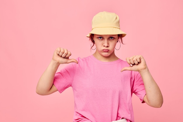 Stilvolles Teenager-Mädchen-Modell in beigem Panama-Pink-T-Shirt mit Handgesten-Lifestyle