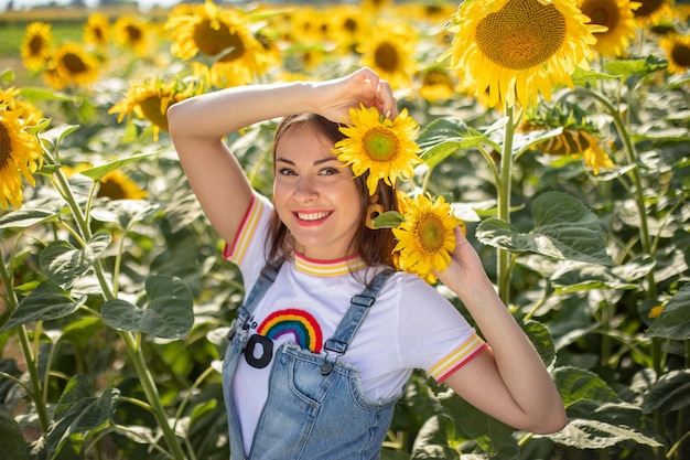 Stilvolles ukrainisches junges Mädchen auf einem Gebiet mit Sonnenblumen