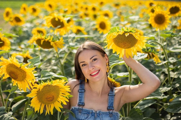 Stilvolles ukrainisches junges Mädchen auf einem Gebiet mit Sonnenblumen