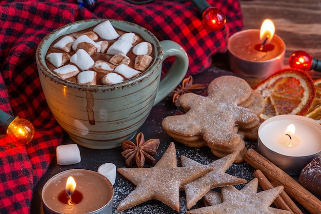 Stimmungsvolle Weihnachtskomposition eine Tasse Kakao mit Marshmallows Kerzen Lebkuchen Kekse süß...