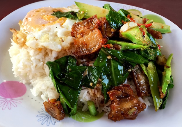 Stir-Fried Kale Gemüse mit knusprigem Schweinefleisch und Spiegelei (Sunny-Side UP) über Reis