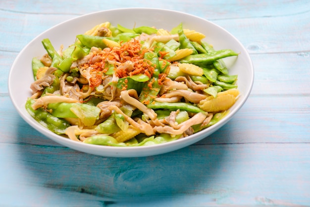 Stir Fry Snow Peas com milho e cogumelos em branco banhado.