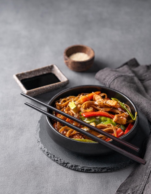 Stirb mit Soba-Nudeln, Fleisch und Gemüse auf dunklem Hintergrund, asiatisches schnelles und gesundes Essen