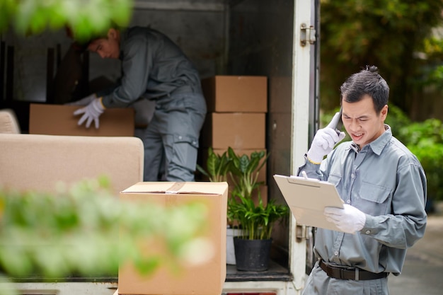 Stirnrunzelnder Mover, der Client anruft