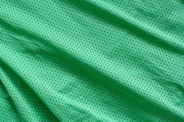 Stoff Textur. Grüner Stoff mit Falten. Rauheiten und Wellen auf der Oberfläche.