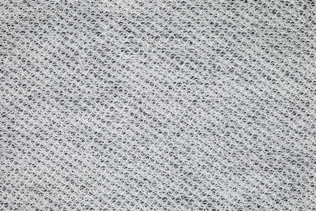 Stoffhintergrund aus weißen Fäden, die gewölbt und gewölbt miteinander verflochten sind. Hintergrundhintergrundtapete mit einheitlichem Texturmuster
