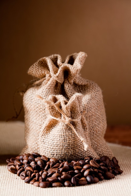 Stoffsäcke mit Kaffeebohnen und braunem Hintergrund