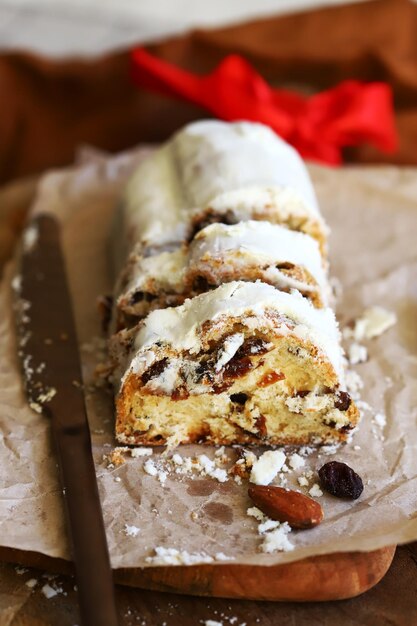 Stollen de Natal cortado em pedaços em uma placa de madeira