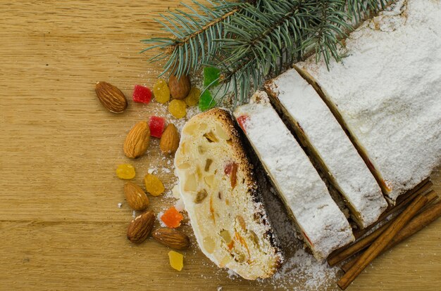 Stollen de Natal em fundo darkfestive com galhos de pinheiro, luzes e bagas