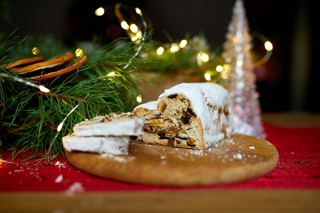 Stollen Deutsches Weihnachtsbrot, Weihnachtsstollen auf Holzhintergrund, traditionelles festliches Gebäckdessert.