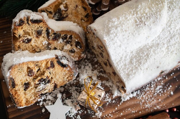 Stollen navideño tradicional hecho de frutos secos y nueces espolvoreadas con azúcar en polvo