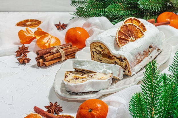 Stollen tradicional bolo alemão pastelaria europeia perfumado pão caseiro com especiarias e frutas secas galhos de árvores de Natal e decorações espaço de cópia de fundo branco