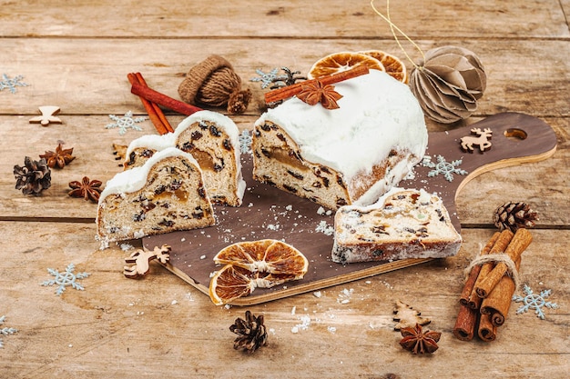 Stollen tradicional bolo alemão pastelaria europeia perfumado pão caseiro com especiarias e frutas secas galhos de árvores de Natal e decorações fundo de madeira copie o espaço