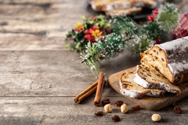 Stollen tradicional de Navidad alemana con frutas y nueces en la mesa de madera