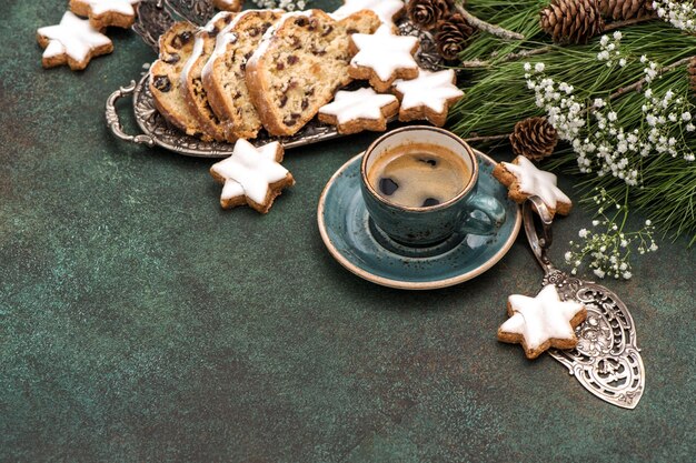 Stollen tradicional pastel de Navidad, galletas, café y decoración. Fondo de comida de vacaciones