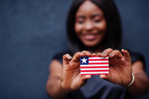 Stolz darauf, eine liberianische Afrikanerin zu sein, die eine kleine Liberia-Flagge in den Händen hält