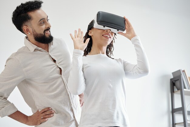 Foto stolzer glücklicher mann, der seine freundin mit einem virtual-reality-helm ansieht, den er ihr geschenkt hat