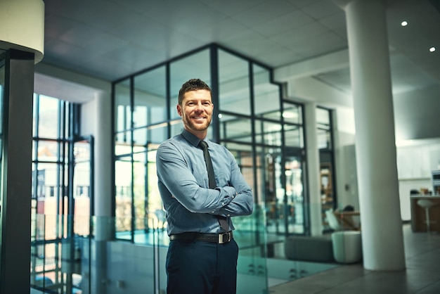 Stolzporträt und reifer Geschäftsmann mit gekreuzten Armen im Büro für die Unternehmensführung Lächeln Arbeit und Unternehmensangestellter mit Selbstvertrauen Glück und professioneller Berater für Führungspersonal