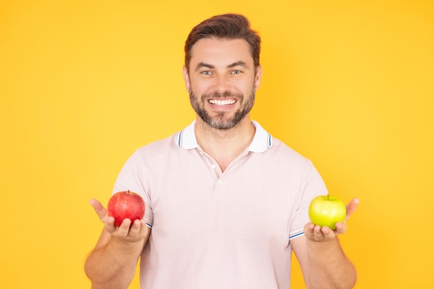 Stomatologie-Konzept Mann mit perfektem Lächeln, der Apfel auf Studio-isoliertem Hintergrund hält Mann isst grün