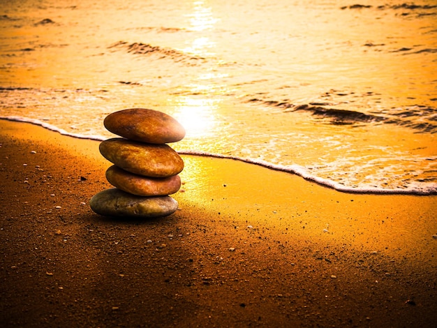 Foto stone zen balance am sandstrand sonnenuntergang sonnenaufgang natur seeküste insel buddhismus