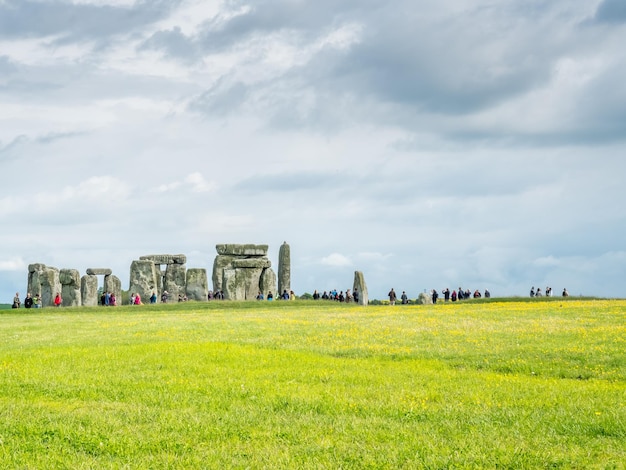 Stonehenge com turista não reconhecido perto de Salisbury Inglaterra sob céu nublado