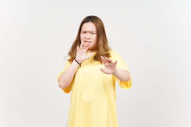 Stoppen Sie die Handablehnungsgeste der schönen asiatischen Frau, die das gelbe T-Shirt trägt, das auf Weiß lokalisiert wird