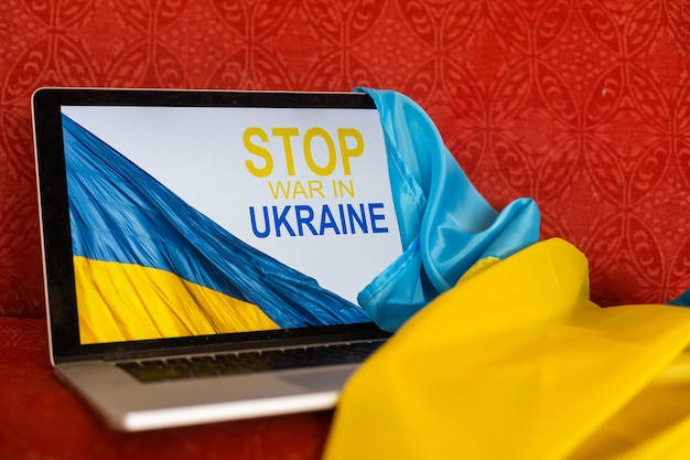 Stoppt den Krieg und Patrioten. Laptop, Flagge der Ukraine.
