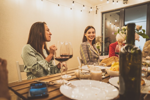 Storytelling-Aufnahmen einer multiethnischen Gruppe von Menschen, die auf einem Dach speisen. Familie und Freunde machen ein Wiedersehen zu Hause